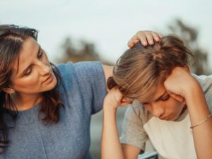 Madre consolando a su hijo mientras él se siente triste