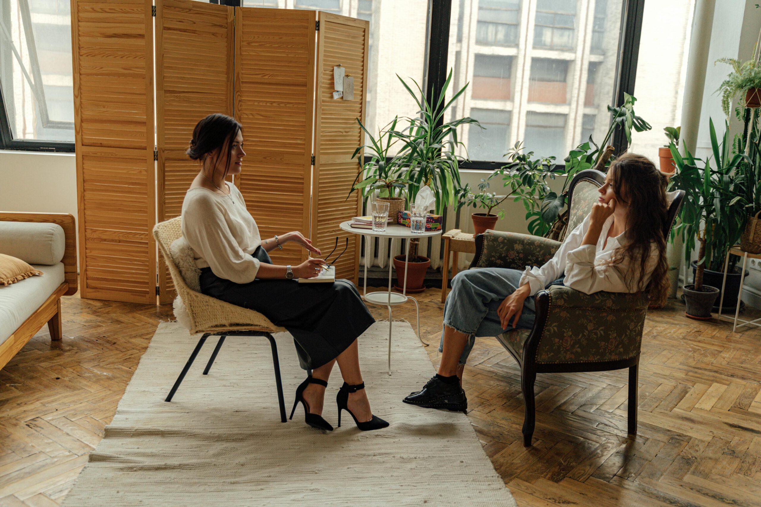 Mujer conversando con una psicóloga en un ambiente acogedor, reflejando el proceso terapéutico