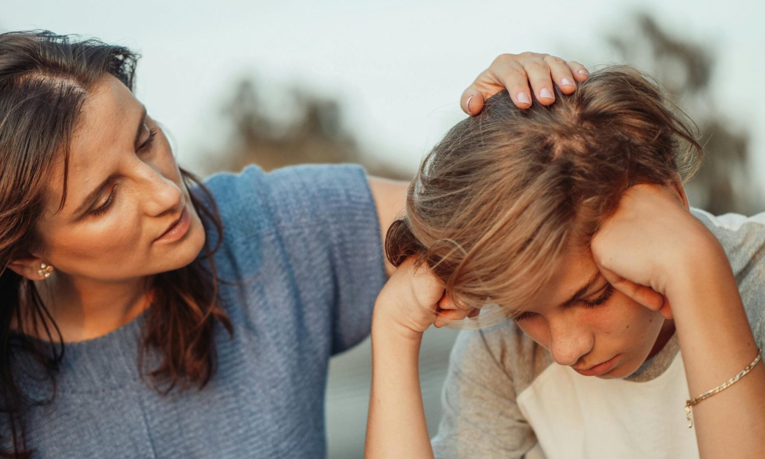 Madre consolando a su hijo mientras él se siente triste