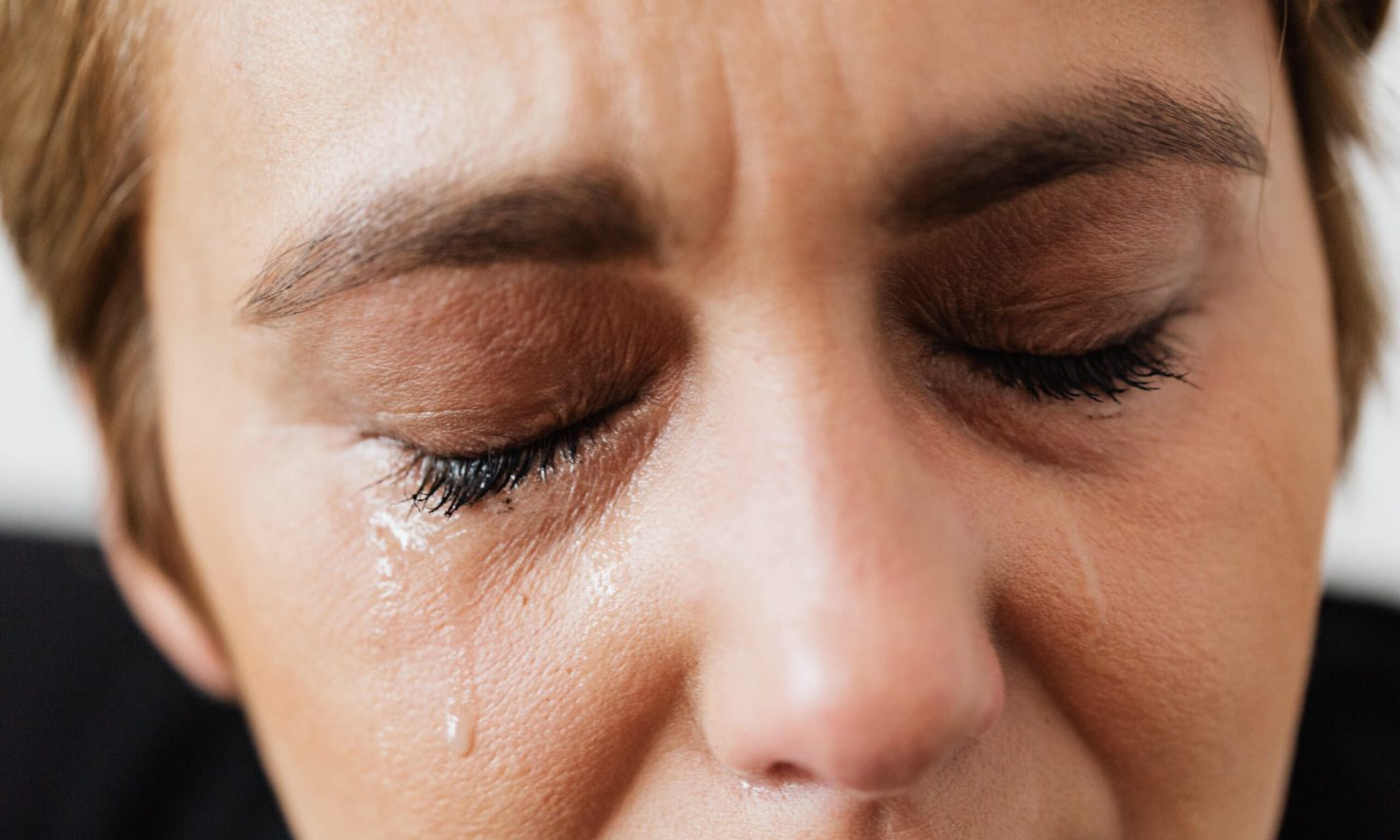 Mujer de mediana edad llorando debido a los síntomas de la fibromialgia