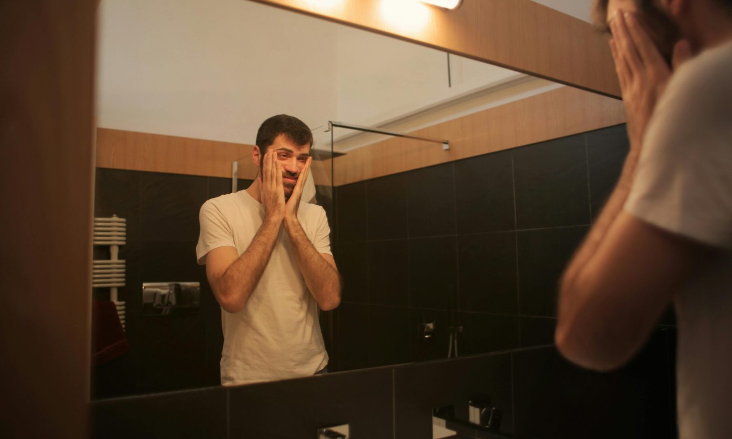 Persona frente al espejo con gesto de preocupación, símbolo de ansiedad y estrés en la vida diaria.