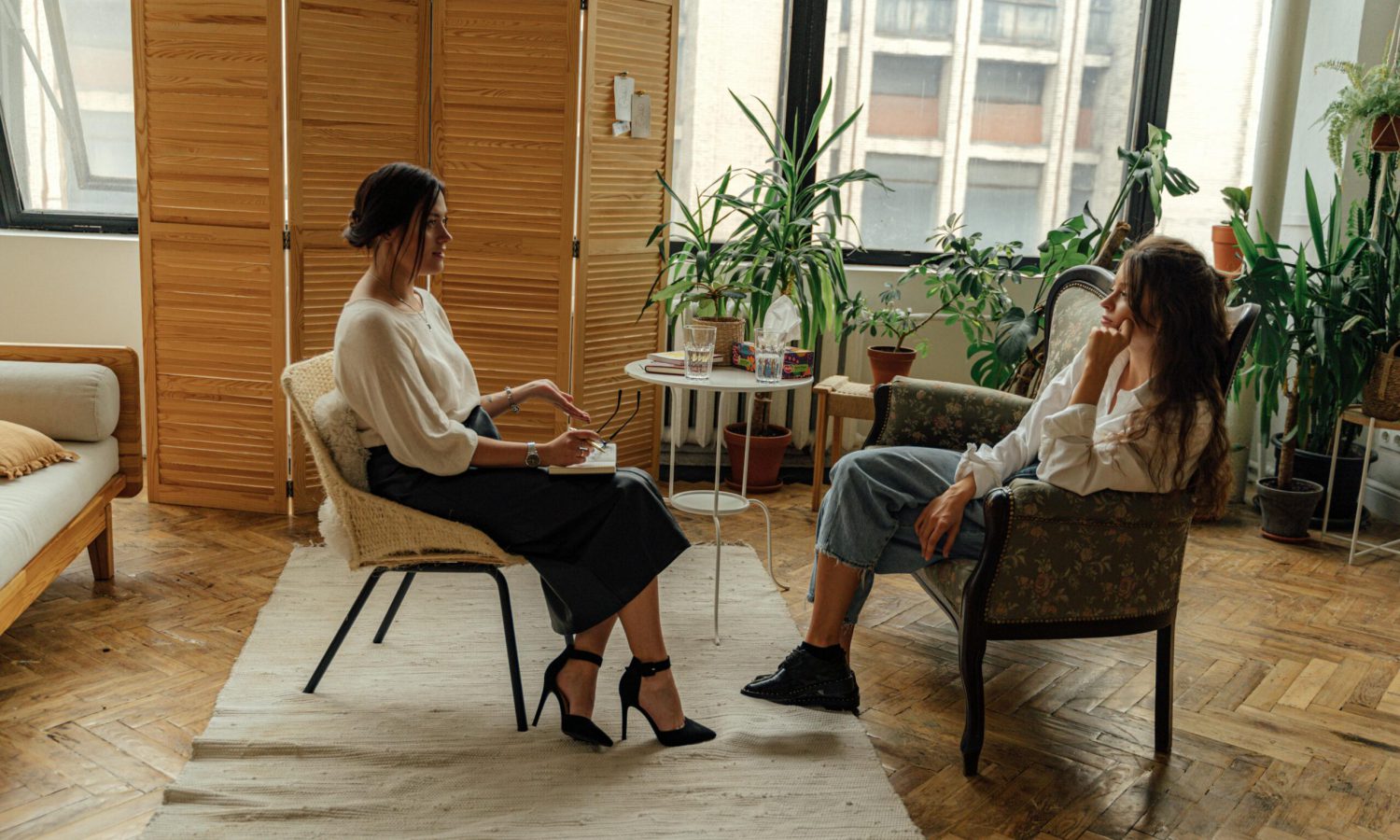 Mujer conversando con una psicóloga en un ambiente acogedor, reflejando el proceso terapéutico